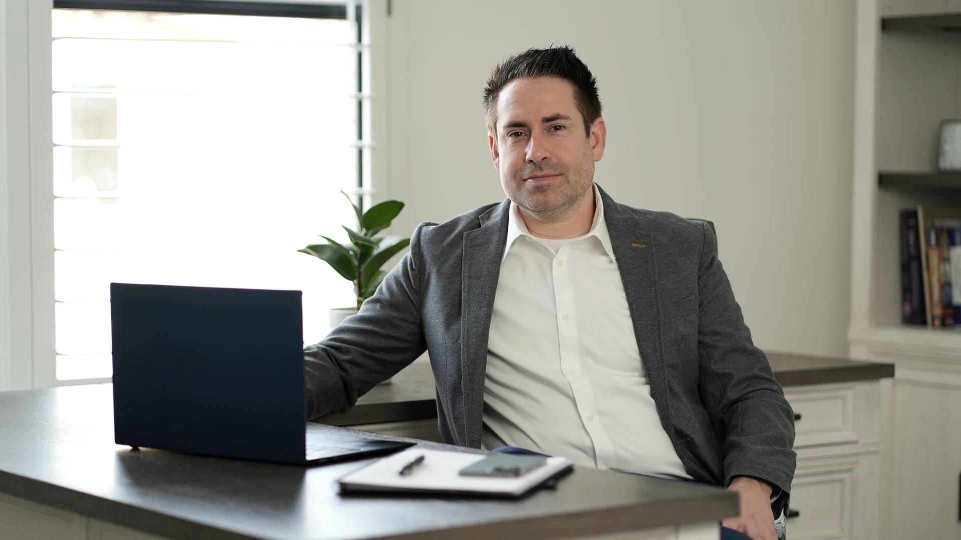 Dr. Justin Schwarting seated at his desk with a laptop, in a bright office